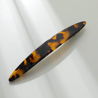 Dark tortoiseshell oblong barrette with amber and black marbled pattern viewed from above