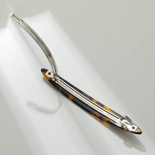 Single tortoiseshell French barrette with automatic clasp extended showing internal spring mechanism