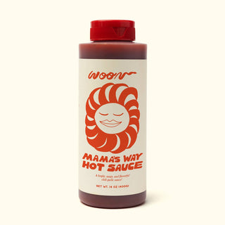 Woon Mama's Way Hot Sauce bottle with cream label featuring red sun logo design and red cap against beige background