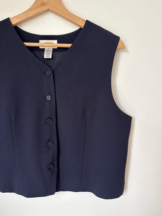 Close-up detail of vintage navy vest showing button placket, v-neckline, and size 14 label at neck