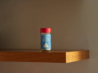 Woon Wok Legend's Seasoning Salt jar displayed on modern wood shelf against neutral background