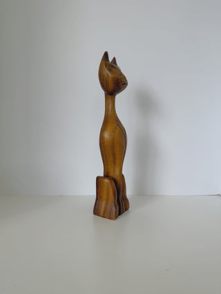 Left side view of vintage wooden cat statue revealing full elongated form from pointed ears to carved feet base with visible wood grain