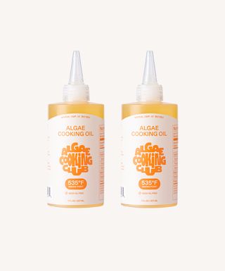 Two bottles of Algae Cooking Oil in 7oz squeeze bottles with clear plastic tips and white caps, showing orange branded labels on beige background