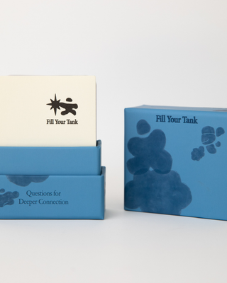 Fill Your Tank card deck with cream-colored card partially pulled out showing star person logo and sample question card visible