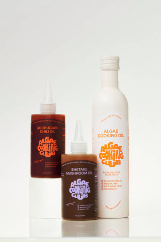 Three Algae Cooking Club bottles: Gochugaru Chili Oil, Shiitake Mushroom Oil, and neutral Algae Cooking Oil arranged together
