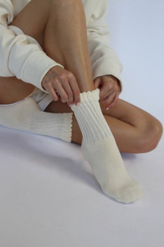 Person wearing Na Nin Fifi socks in Alabaster and a matching outfit on a light background