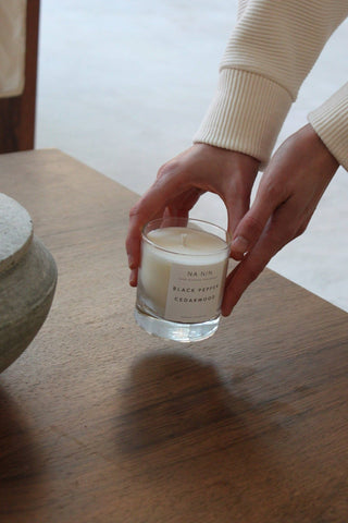 Candle on table touched by a pair of hands