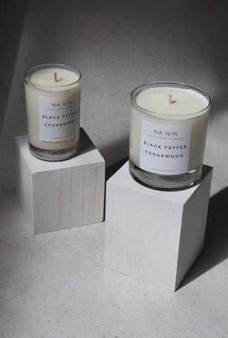 Candles in two sizes on blocks on neutral background