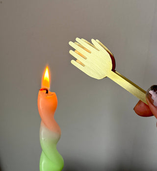 Hand snuffer held by lit candle