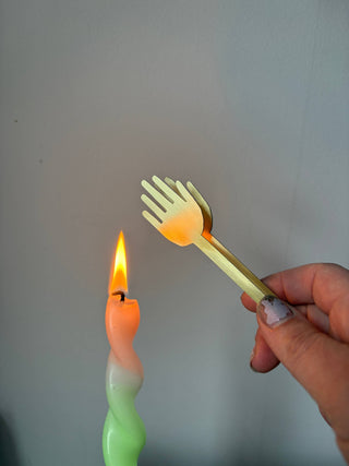 Candle snuffer held by lit flame