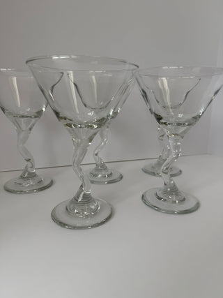Close-up of three vintage zig zag stem martini glasses showing varied twisted stem patterns and clear glass construction