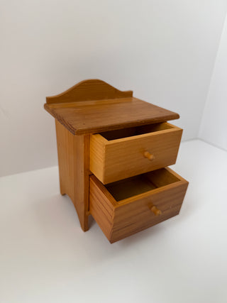 Angled view of vintage wooden jewelry box with both drawers partially opened, revealing storage compartments and natural wood grain details