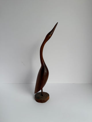 Side view of vintage wooden crane bird figure displaying elegant curved neck and smooth carved body