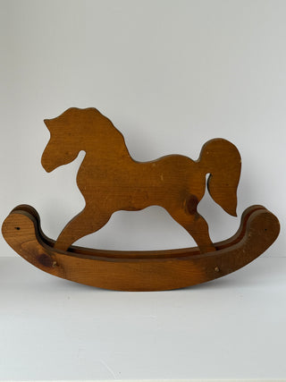 Vintage wooden rocking horse with natural brown finish shown from side profile against white background