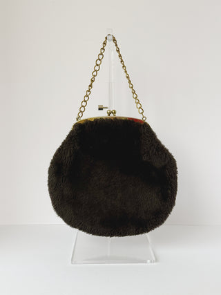 Front view of vintage brown faux fur clutch purse showing full circular shape, luxurious texture, and gold hardware with chain strap