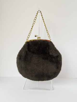 Vintage espresso brown faux fur round clutch with gold kiss-lock clasp and chain handle displayed on clear acrylic stand against white background