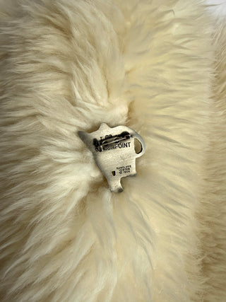 Back view of vintage Rawcliffe pewter cat pin showing maker's mark and pin point clasp on fur background