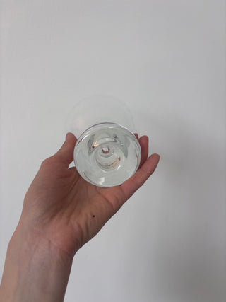 Bottom angle view of vintage glass goblet showing detailed twisted stem structure held in palm