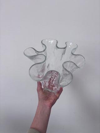 Vintage clear glass sculptural vase held in hand, bottom angle view showing organic petal-like form and wavy edges