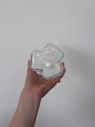 Top-down view of vintage clear glass vase held in hand showing four-point asymmetrical star-shaped opening