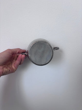 Bottom view of vintage pewter sugar bowl showing base and handle attachment points