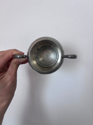 Top-down view of vintage pewter sugar bowl interior showing patina and depth