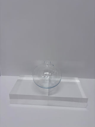 Side view of vintage glass flask vase showing curved profile and opening at top on white stepped display