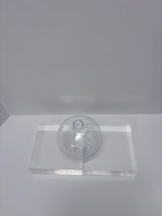 Vintage clear glass round flask vase with two circular porthole details displayed on white acrylic platform against white background