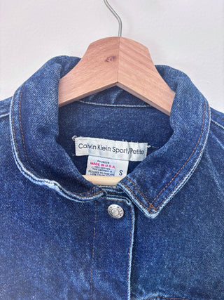 Close-up detail of Calvin Klein Sport Petite label inside collar showing size S, made in USA tag visible
