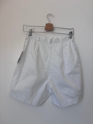 Back view of vintage white cotton shorts on hanger showing clean lines and structured fit with elasticated waistband detail