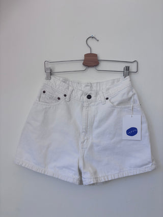 Front view of vintage white Levi's high-waisted denim shorts on wooden hanger with KALEIDOS tag attached