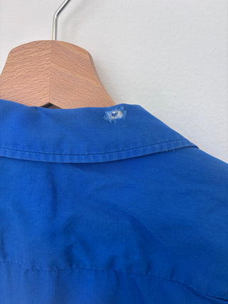 Close-up of collar and upper back showing fabric texture and slight wear on vintage blue Hilton work shirt