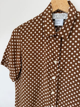 Close-up detail of brown polka dot shirt collar, buttons, and Petite Sophisticate label with size and fabric information visible