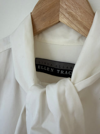 Close-up of Ellen Tracy brand label inside cream silk blouse collar with pussy bow detail