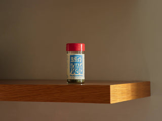 Woon Sea Moss Seasoning jar displayed on wooden shelf against tan wall showing full product packaging