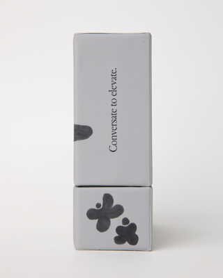 Narrow side of card deck box showing 'Conversate to elevate' tagline vertically with abstract black shapes